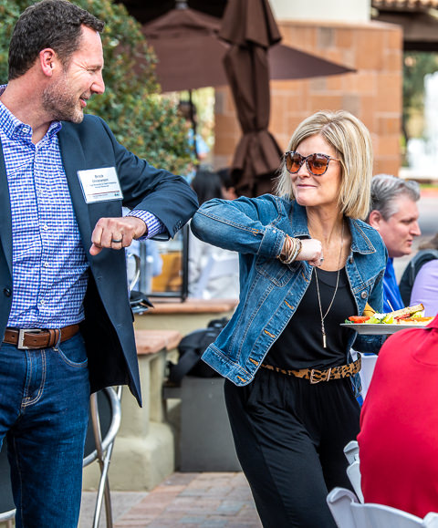 Two managers for a Fortune 500 company greet each other with an elbow bump at a company leadership summit in Scottsdale, AZ.