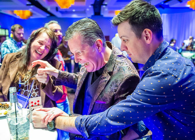 A magician performs tableside card tricks during a McKesson Corporation event at Mystic Lake Casino.