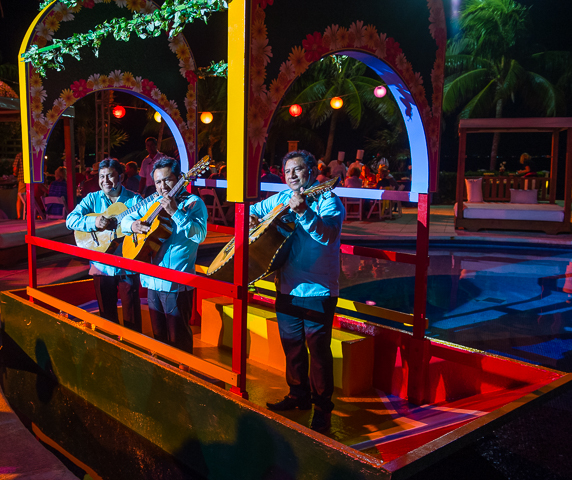 Traditional Mexican musicians perform for a corporate event while floating in a boat at a Cancun resort.