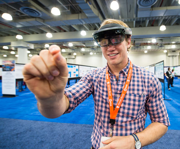 A student wearing augmented reality goggles interacts with the virtual world he sees.