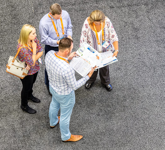 HITEC trade show attendees consult the map and vendor list.