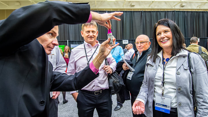 Magician David Farr performs an illusion to the delight of attendees at a business resource fair in Minneapolis.