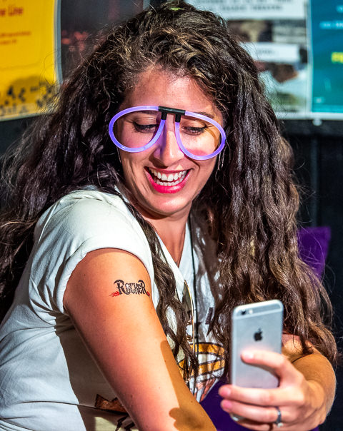 An association party-goer at First Avenue in Minneapolis photographs her temporary 'Rocker' tattoo for posterity.