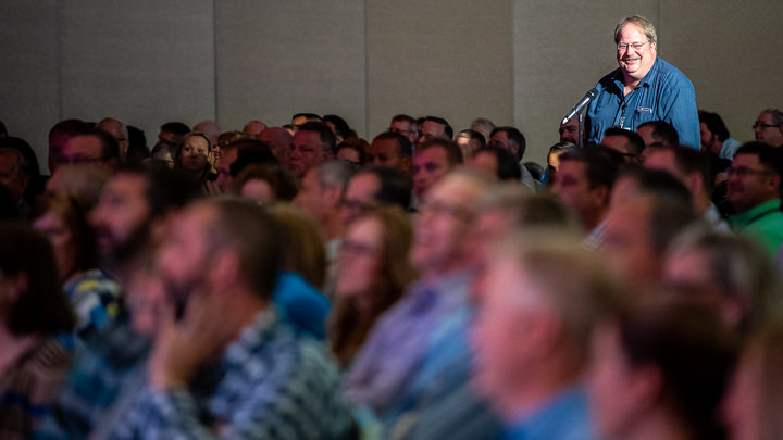 During a session at a corporate conference in San Francisco an attendee stands to ask a question.