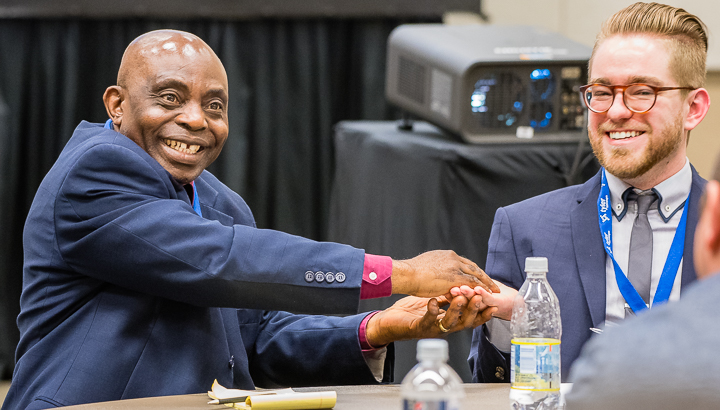 A working session member makes a point by holding his colleague's hand at an association conference in Atlanta.