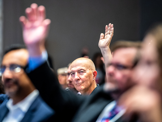 In response to a speaker's question, an attendee raises his hand during the Council on Licensure Enforcement and Regulation conference in Minneapolis.