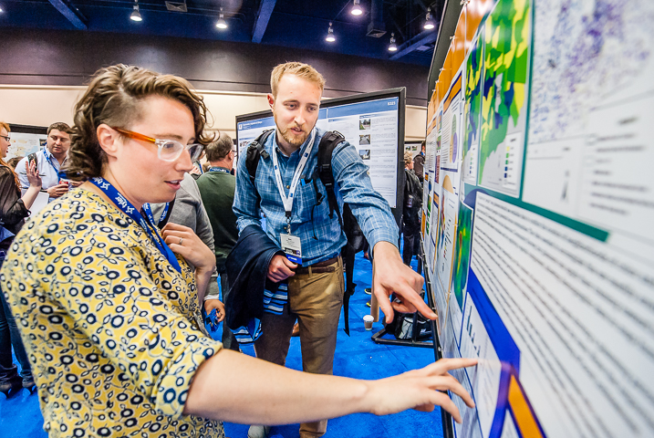 A planning student explains her research poster to a professional planner in Seattle.