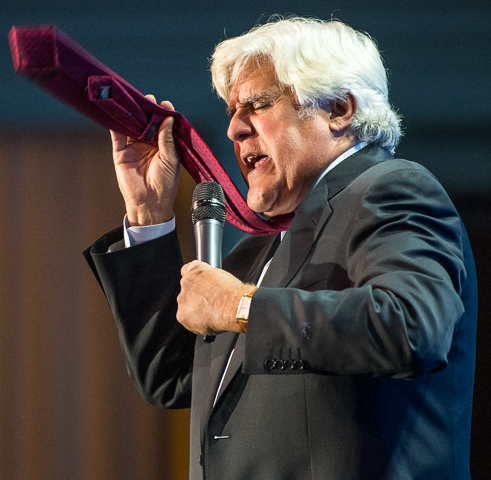 Jay Leno flutters his tie while portraying an easily offended person during a private corporate show.