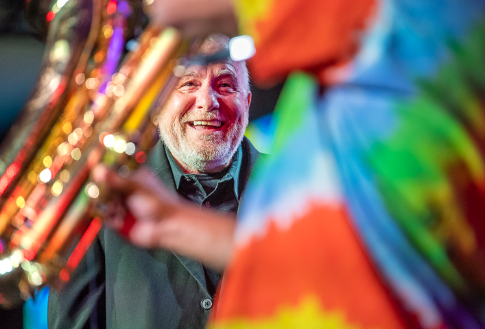 A Joe Cocker impersonator enjoys a saxophone solo during a 'Summer of Love' show at a corporate event in San Francisco.