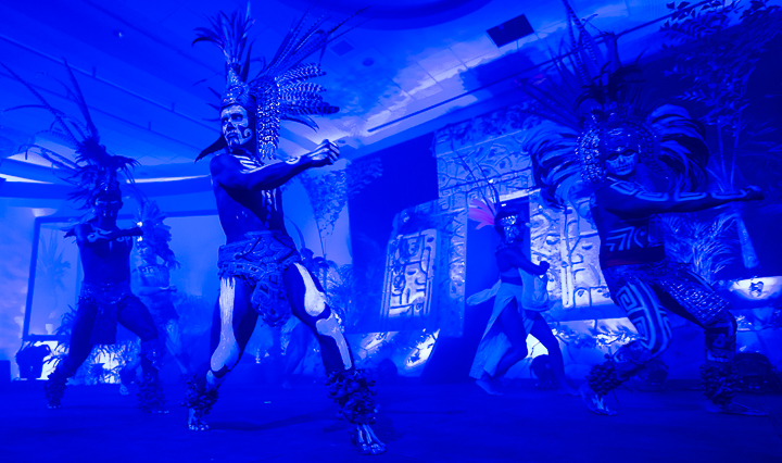 Mexican warrior dancers perform in front of a replica Mayan temple for a corporate conference in Cancun.