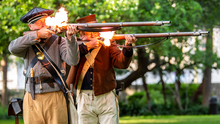 Historical re-enactors fire muskets at The Alamo in San Antonio as part of a reception for a corporate conference.