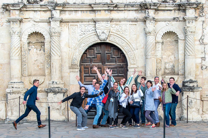 Members of a regional sales office for a Fortune 500 company have fun with their team photo in front of The Alamo in San Antonio.
