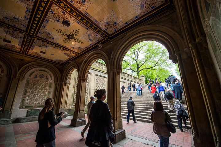 Conference attendees on a walking tour of Central Park pass through the arched  Bethesda Terrace Arcade.