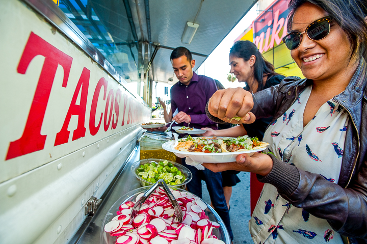 A group of association conference attendees stops at a taco truck as part of a food truck tour of East Los Angeles.