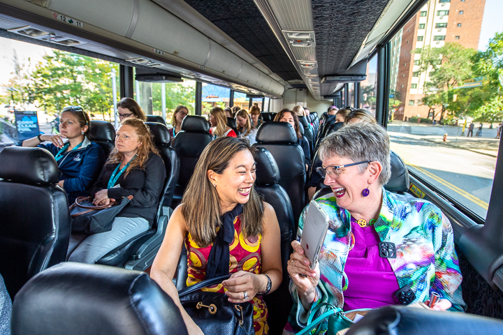 Conference attendees share a laugh on a bus headed for an off-site architectural tour.