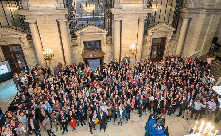 A large association group poses for a group photo in the entry hall of the main New York City Public Library.