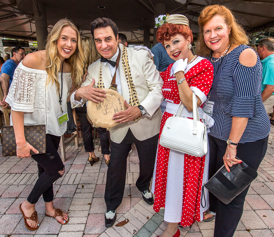 Ricky Ricardo and Lucille Ball impersonators pose with business conference attendees in South Florida.