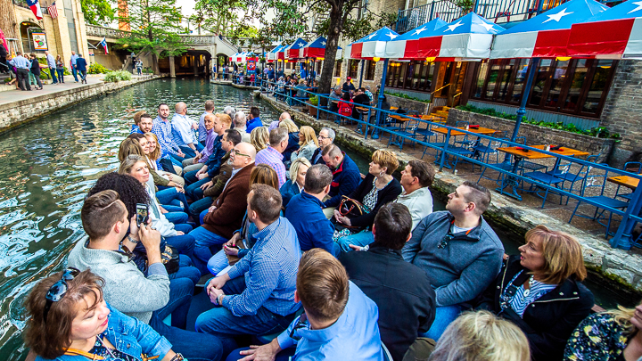 Corporate sales conference attendees head to dinner on a boat cruising along San Antonio's Riverwalk.