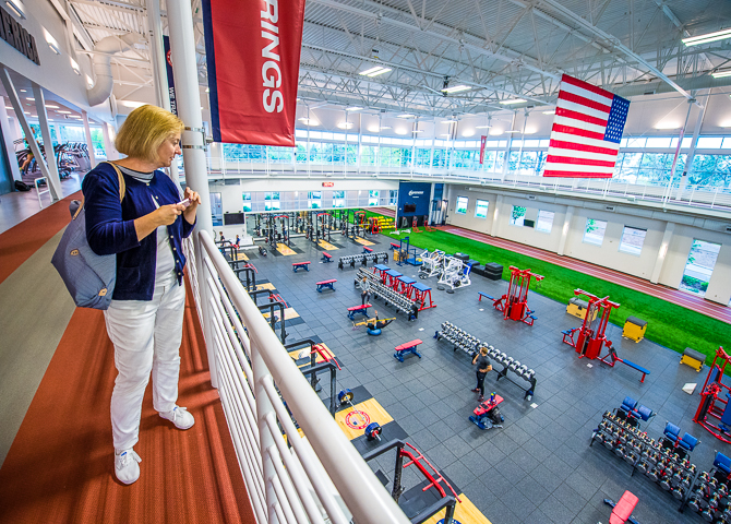 A conference attendee touring the US Olympic Training Center in Colorado Springs looks over the weight room.
