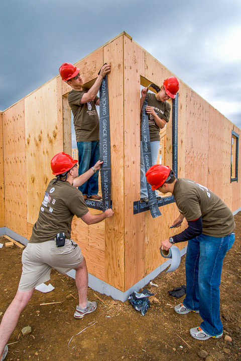 A Homes for Our Troops volunteer Build Brigade works on windows at a home under construction for a wounded Iraq war vet.