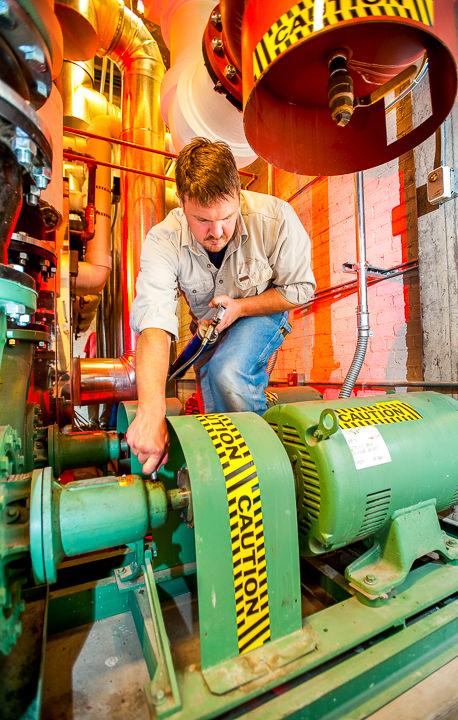 A technician performs a pressure check on an industrial pump at the Midtown Exchange building in Minneapolis.