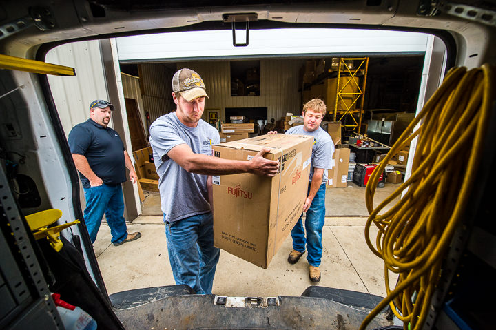 Employees of Hawk-I Plumbing in Storm Lake, Iowa load a Fujitsu Halcyon unit into their truck.