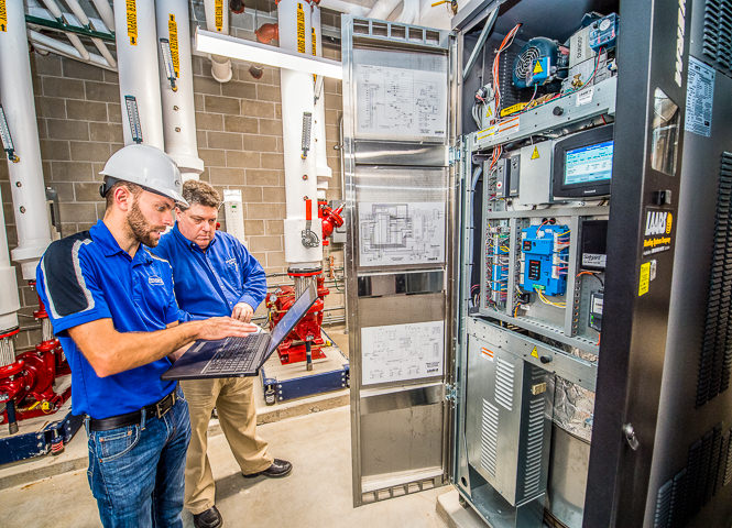 Technicians run diagnostics on a recently installed Laars Magnatherm commercial boiler.