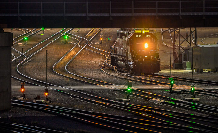 A lone locomotive moves through rail yards in northeast Minneapolis at night.