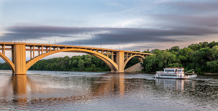 A sternwheel paddle boat sails under the newly renovated Franklin Avenue Bridge over the Mississippi River in Minneapolis.
