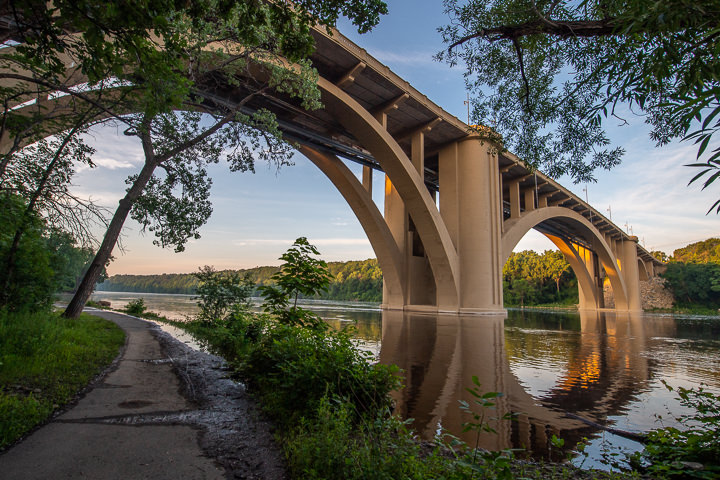 A water-level view of the newly refurbished Franklin Avenue bridge over the Mississippi River in Minneapolis at sunset.